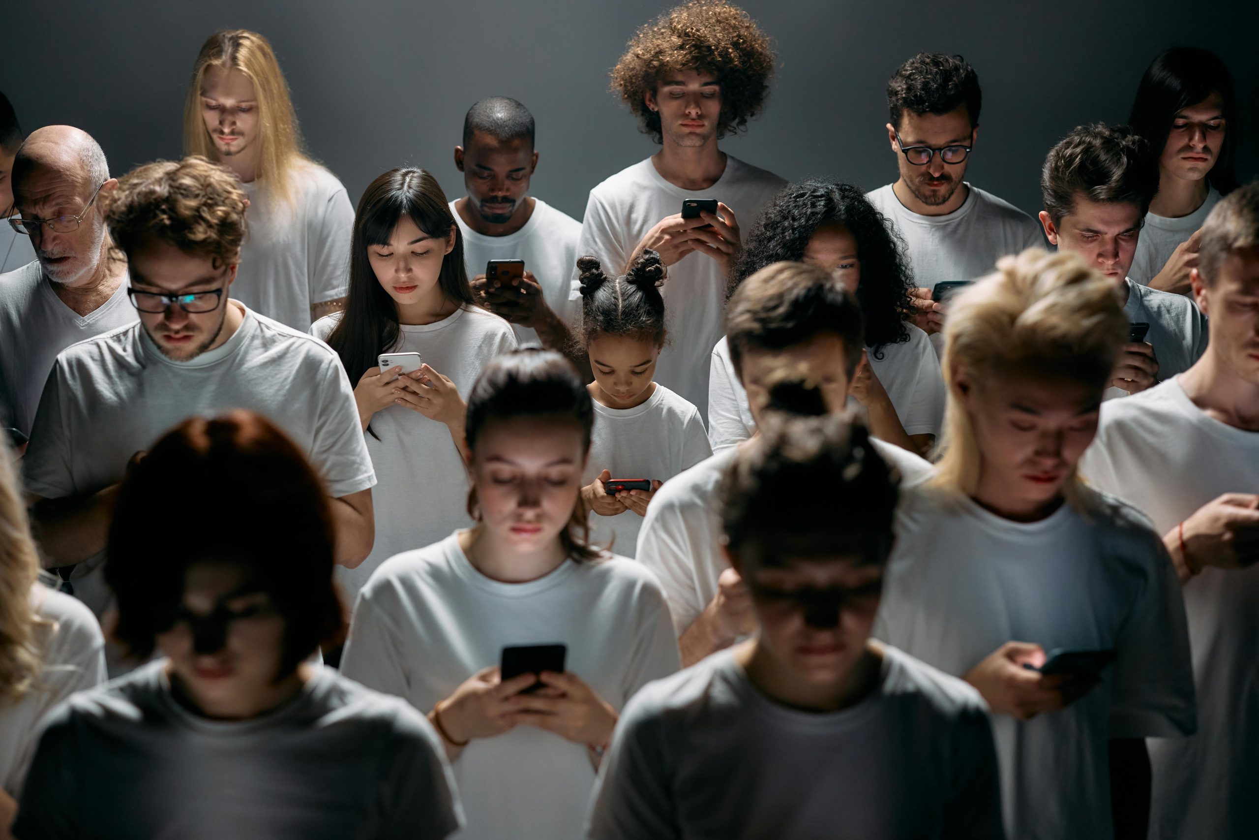 Children and adults wearing white shirts holding their smartphones